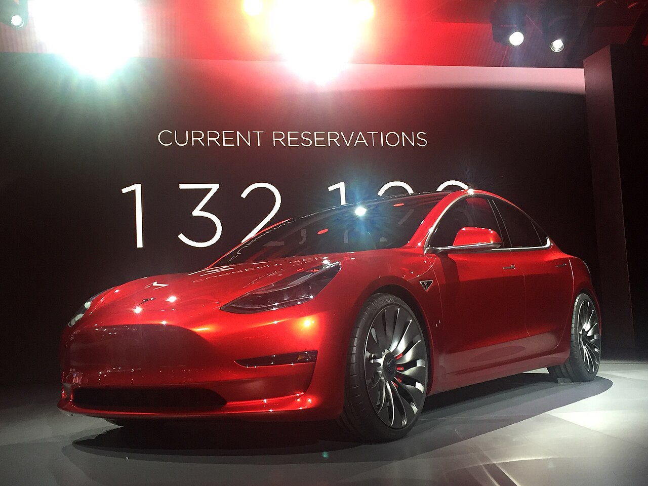 一辆红色特斯拉Model 3,鲜亮的车漆体现日常清洁与漆面养护的重要性