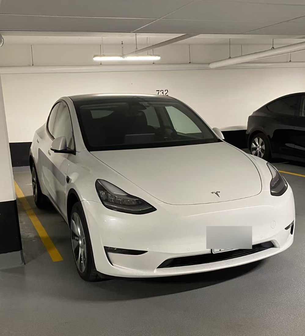 Lifei Zhou 的白色 2022 款特斯拉 Model Y 长续航版,停在加拿大安省的公寓车库