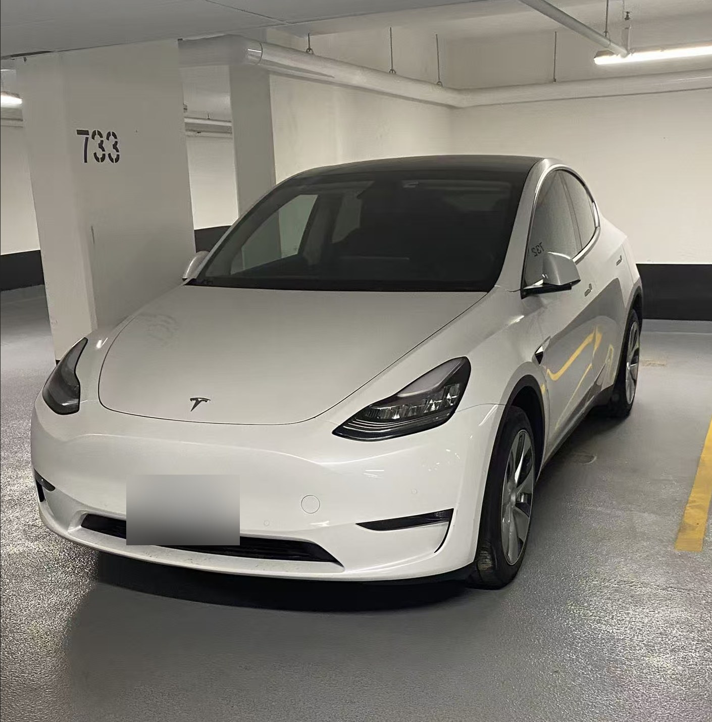 Lifei Zhou 的白色特斯拉 Model Y 前侧四十五度视角,安省绿色环保车牌,车牌号已打码