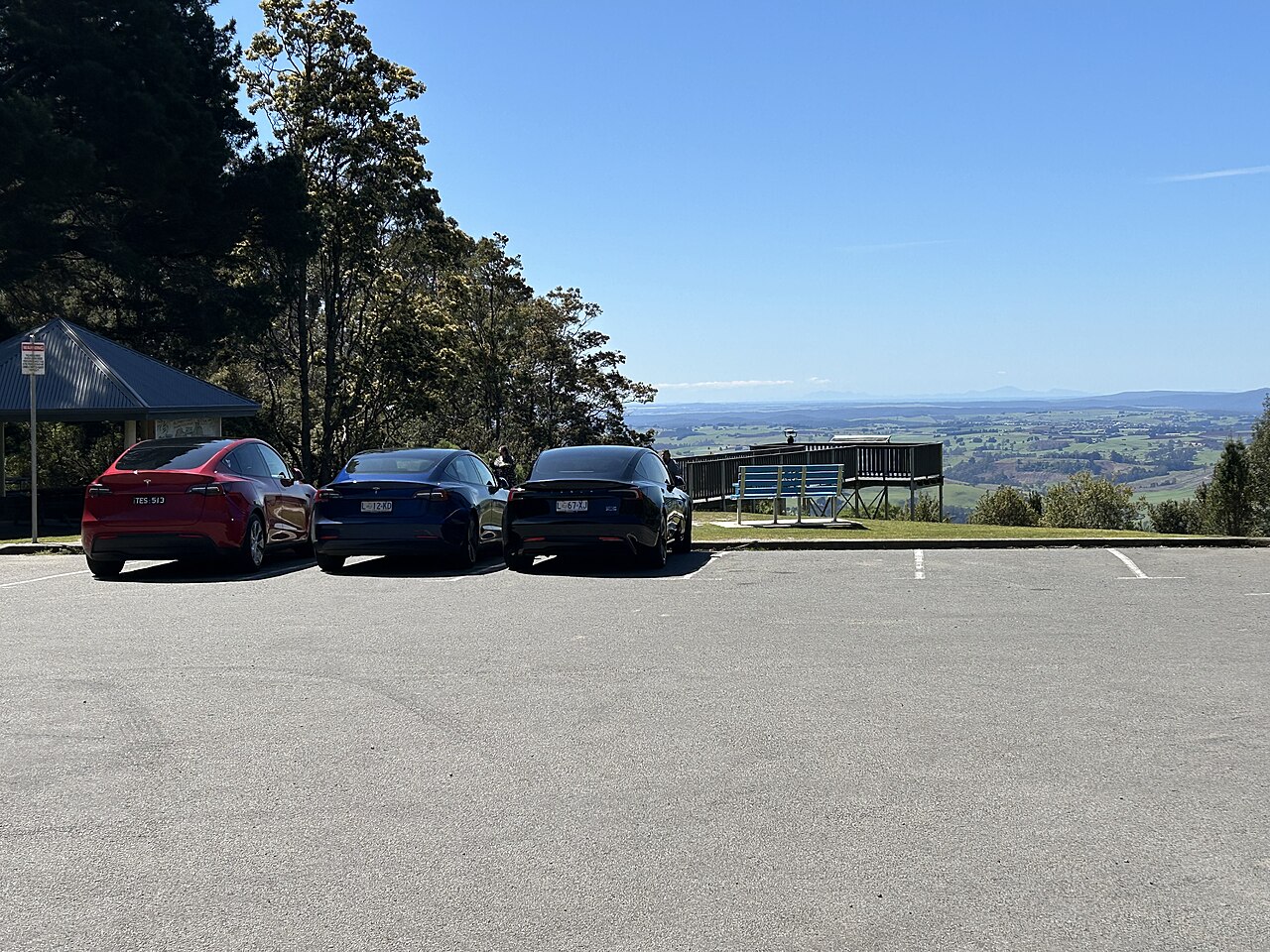 tesla-cross-country-road-relocation 两辆特斯拉停在盘山公路观景台,象征跨州跨省搬家长途自驾