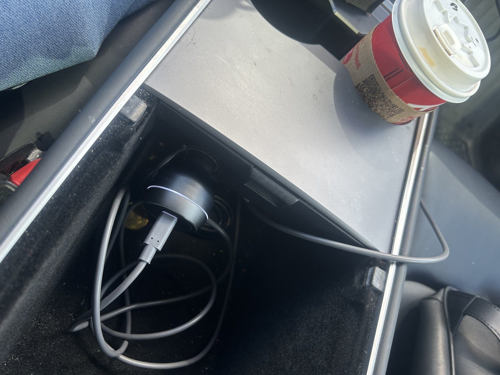 JOWUA 165W car charger plugged into the 12V socket at the back of a Tesla Model Y centre console, with a USB-C cable in its main port