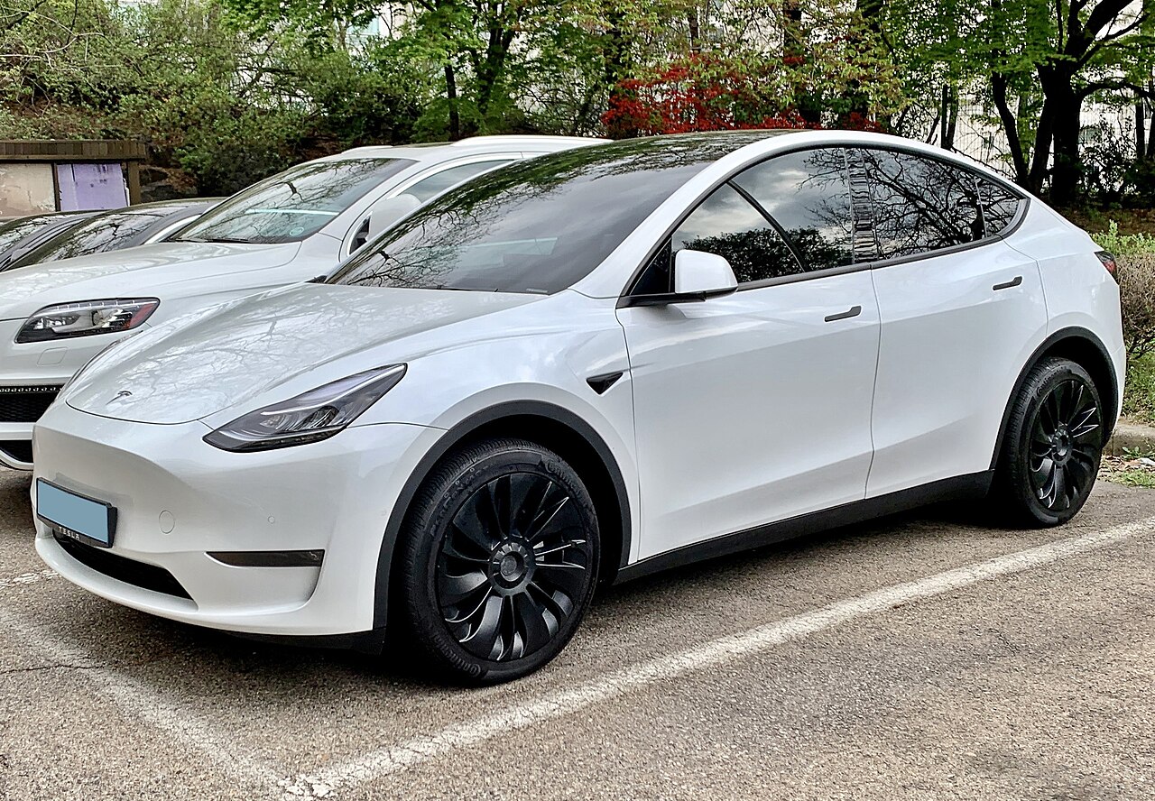 停在住宅区停车位的白色特斯拉Model Y,适合父母探亲期间的家用代步车