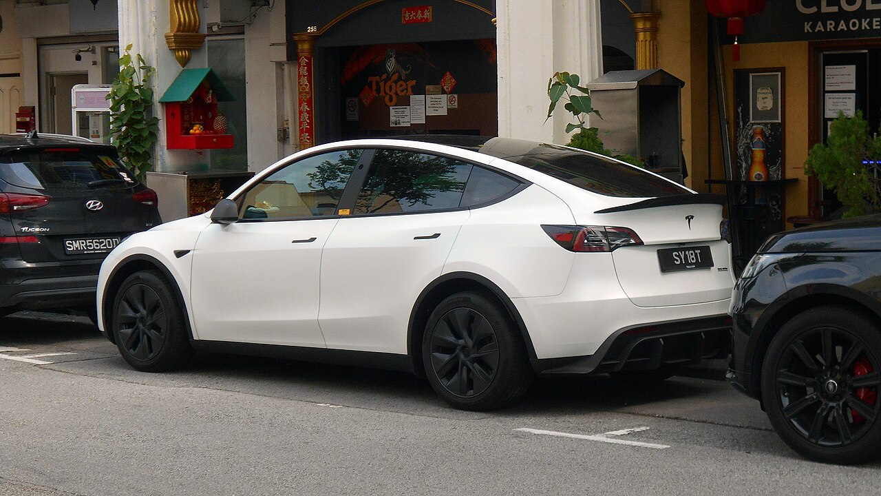 停在路边的白色特斯拉Model Y,临街停车需开启哨兵模式防砸窗盗窃